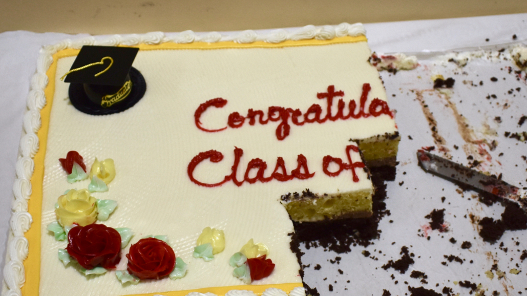 A half-eaten sheet cake, with the remaining words on top reading: "Congrat... Class of..."