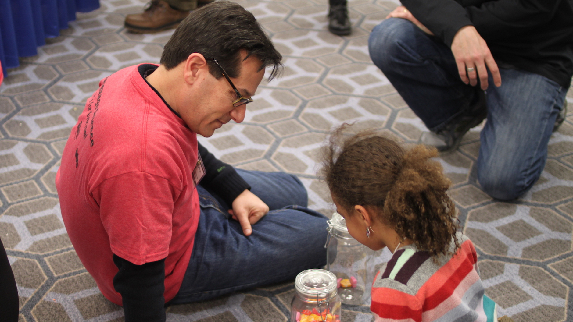Professor Jeff Lidz, sitting on the floor with a girl, maybe 7 years old, playing games that teach her about the psychology of counting